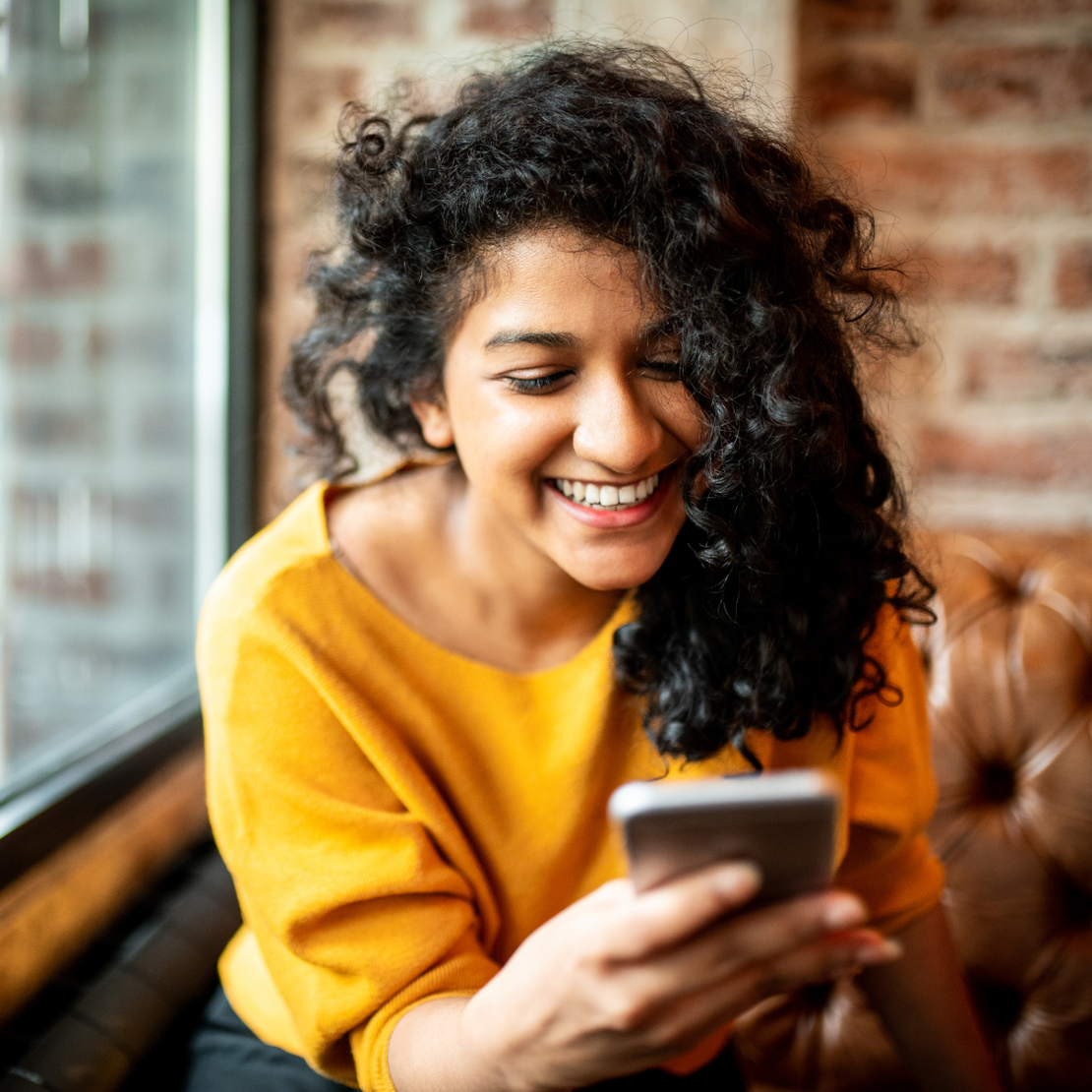 A lady using her mobile phone to bill her customers, mobile POS app interface, diverse payment options, real-time sales tracking